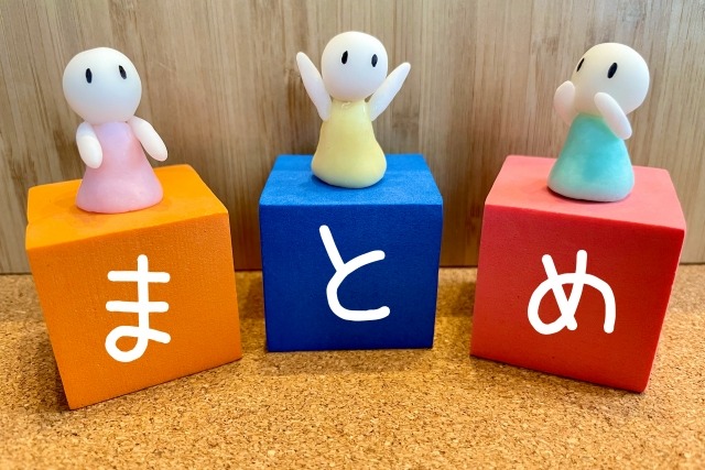 「まとめ」と一文字ずつ書かれたカラーブロックの上に人型の人形が乗っている